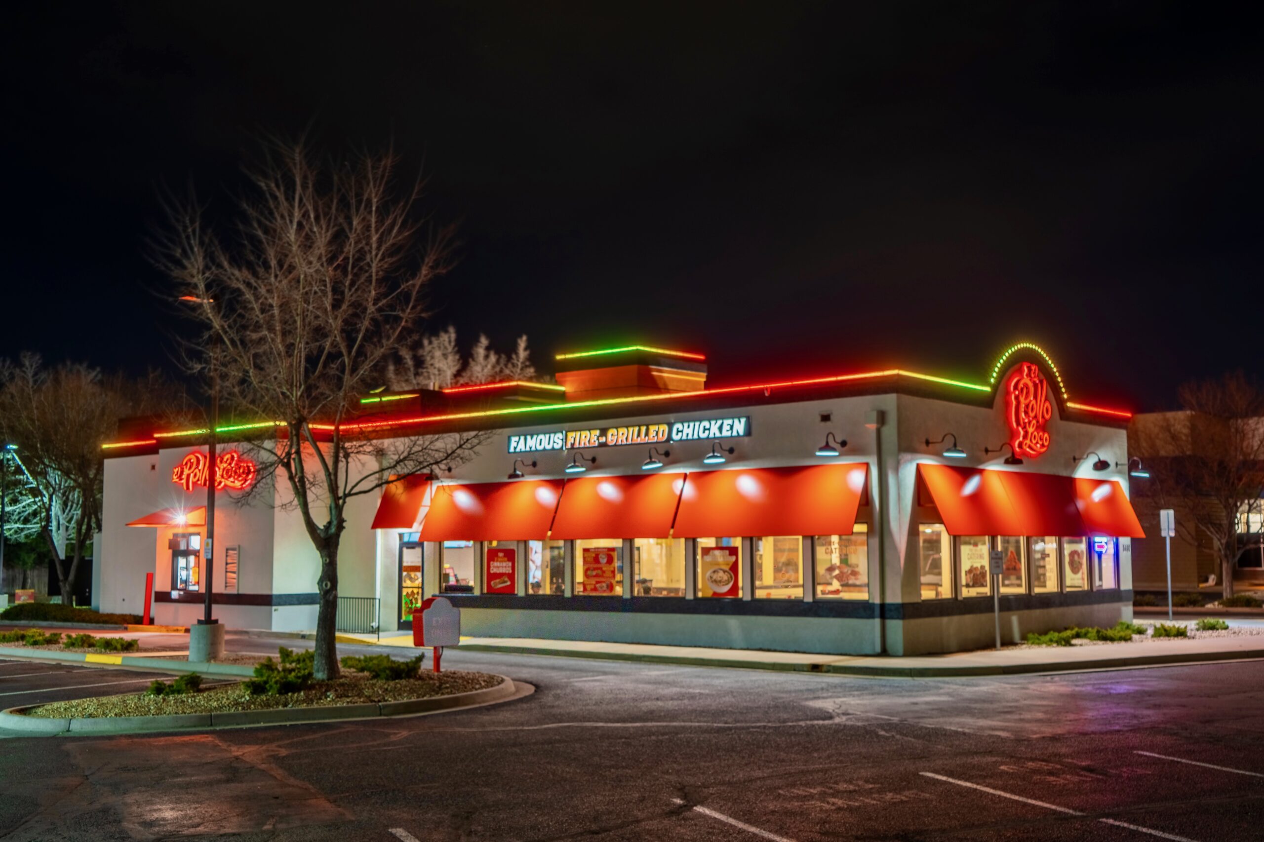 Restaurant storefront outlined in red and green holiday lights at night
