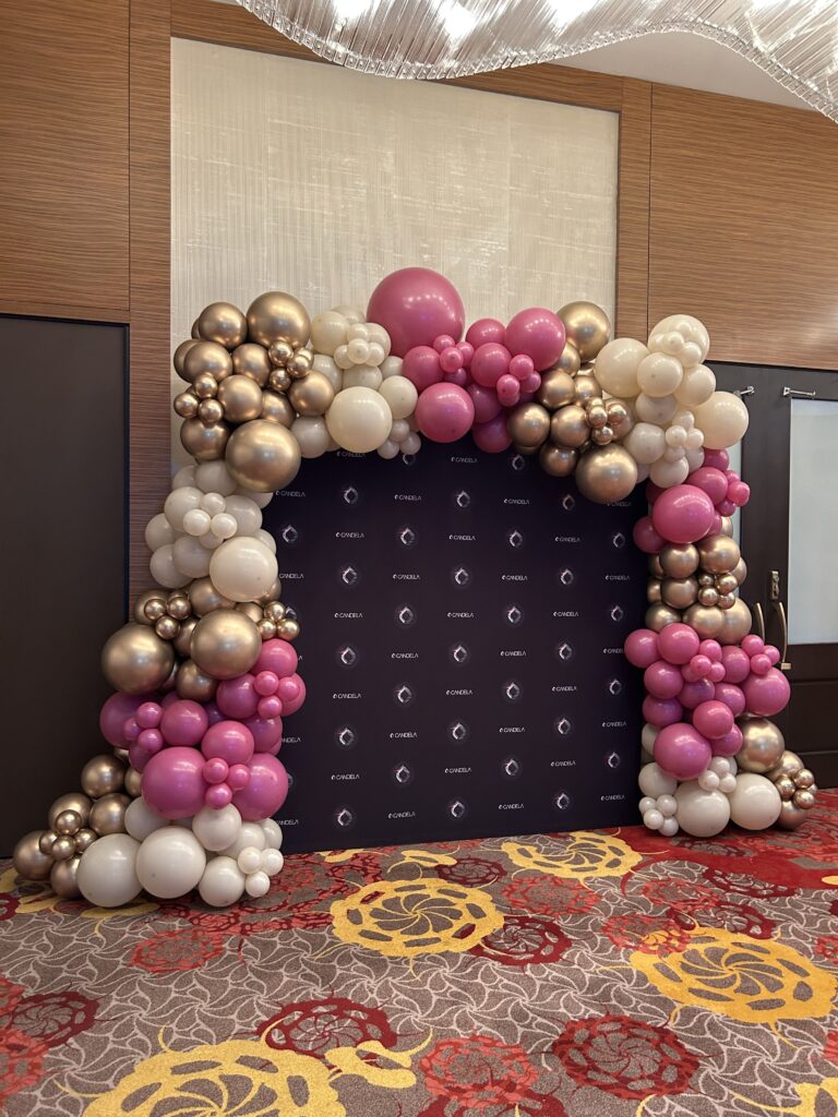 Gold, pink and cream organic balloon garland around a photo backdrop