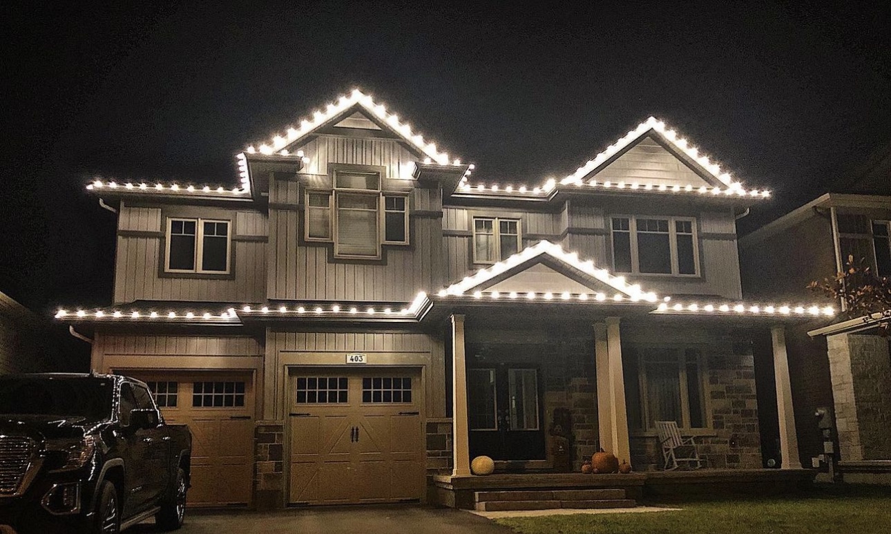Warm white roofline Christmas lights on a two-story home