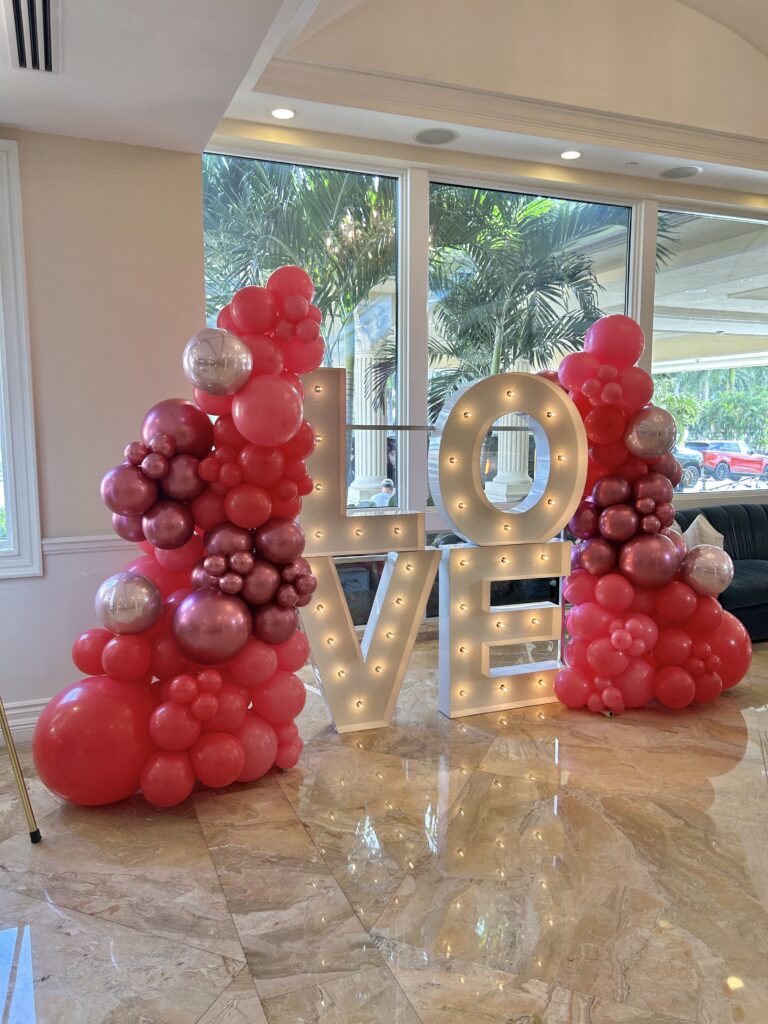 Light-up LOVE marquee letters with red balloon garland