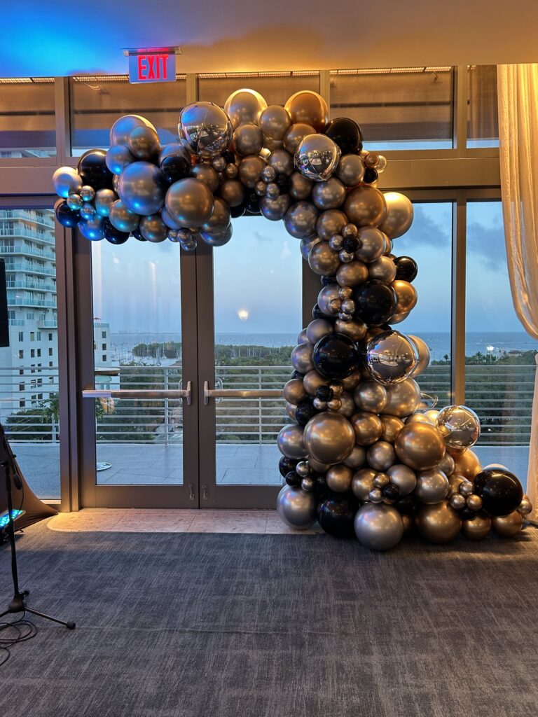 Black and gold balloon garland framing an entrance